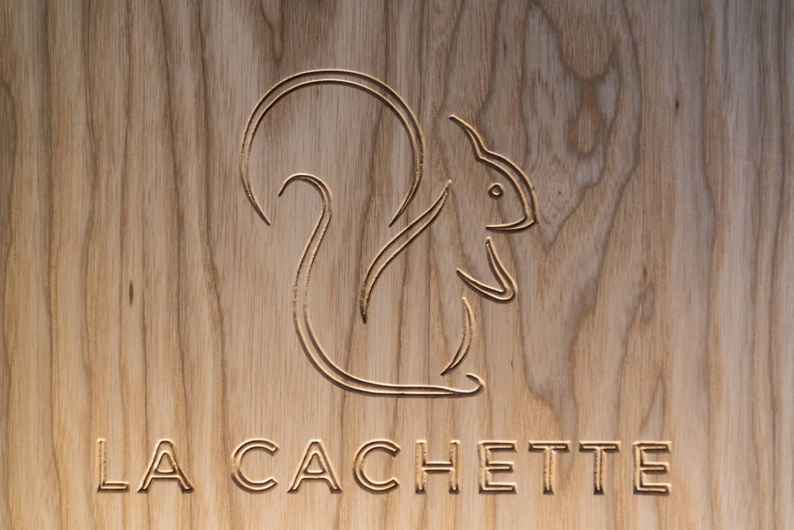 Logo de l'hôtel LA CACHETTE incrusté dans du bois